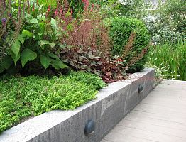 Verhoogde border met oplopende beplanting en In-lite verlichting.