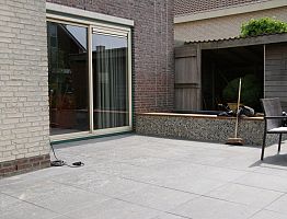 De bestrating is strak gelegd, dit past bij het huis en de overige materialen.