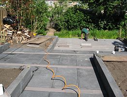 Tegels met stroken ertussen en een terras van steenstroken 