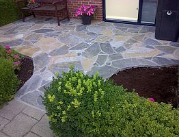 Bestrating van flagstones in cement.