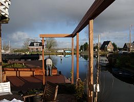 Materiaal van de pergola sluit aan bij grondkering en vlonder.