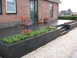 Grondkering van betonbielsen met trap en plantenbak.