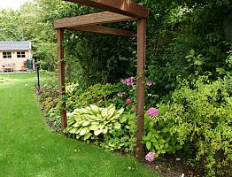 Op maat gemaakte pergola verbindt de verschillende tuindelen.