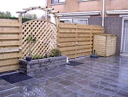 Schutting met trellis toogscherm als onderbreking.