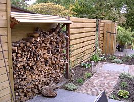 Opslag voor haardhout verwerkt in de schutting.