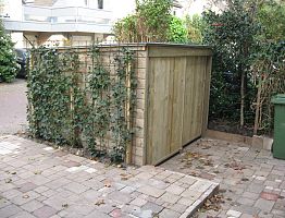 Afsluitbare fietsenberging begroeid met Hedera.