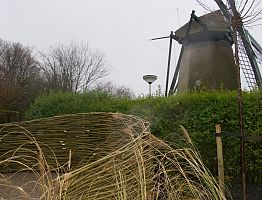 Aan de voet van de molen is een knusse zithoek gemaakt van gevlochten wilgtentenen.