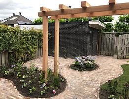 Sierbestrating met pergola en beplanting